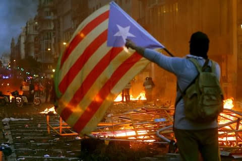 People wave 'Esteladas' flag, the unofficial flag typically flown by Catalan independence supporters, during incidents with police as thousands of people take part in one of the so-called 'Marches for Freedom' along Pelayo street in Barcelona - Credit: QUIQUE GARCIA/EPA-EFE/REX&nbsp;