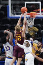 Minnesota's Luke Loewe (12) scores between Pittsburgh's John Hugley (23) and Jamarius Burton (11) with the go-ahead basket in the closing seconds of an NCAA college basketball game Tuesday, Nov. 30, 2021, in Pittsburgh. Minnesota won 54-53. (AP Photo/Keith Srakocic)