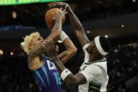 Charlotte Hornets' Kelly Oubre Jr. is fouled by Milwaukee Bucks' Bobby Portis during the first half of an NBA basketball game Wednesday, Dec. 1, 2021, in Milwaukee. (AP Photo/Morry Gash)