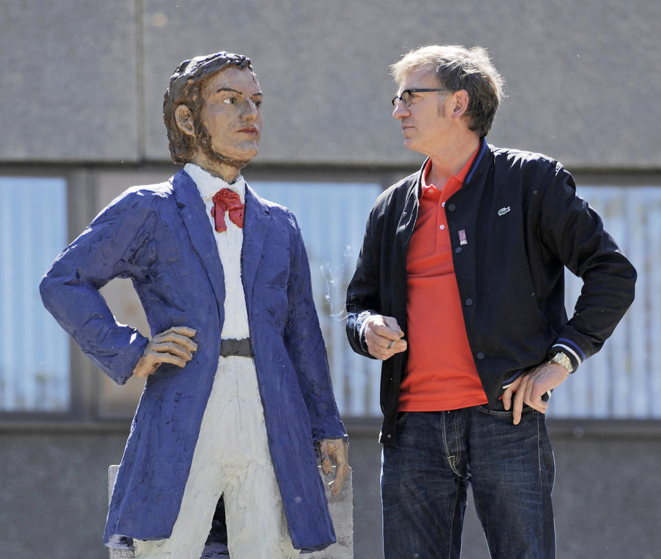 FILE - In this May 15, 2013 file photo German artist Stephan Balkenhol, right, stands besides a part of his Richard Wagner Monument during the installation in Leipzig, central Germany. The Wagner monument will be unveiled Wednesday, May 22, 2013, to celebrate the German composer's 200th birthday. It shows a young Wagner overshadowed by his older, famous self. Some of Wagner's works will be performed later in the day in Bayreuth, where the composer's descendants organize an annual music festival. (AP Photo/Jens Meyer, File)