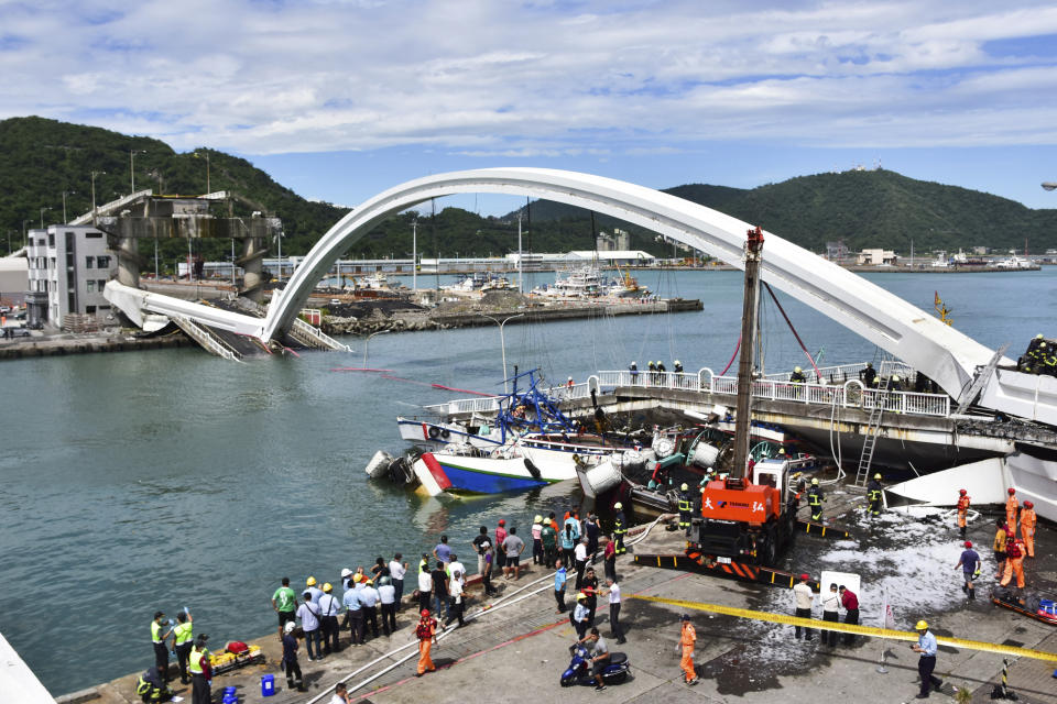 Rescuers work near the site of a collapsed bridge in Nanfangao, eastern Taiwan. Tuesday, Oct. 1, 2019. A towering bridge over a bay in eastern Taiwan has collapsed sending an oil tanker truck falling onto boats in the water below. A disaster relief official said the collapse set off a fire and at least 10 people have been hurt. (AP Photo)