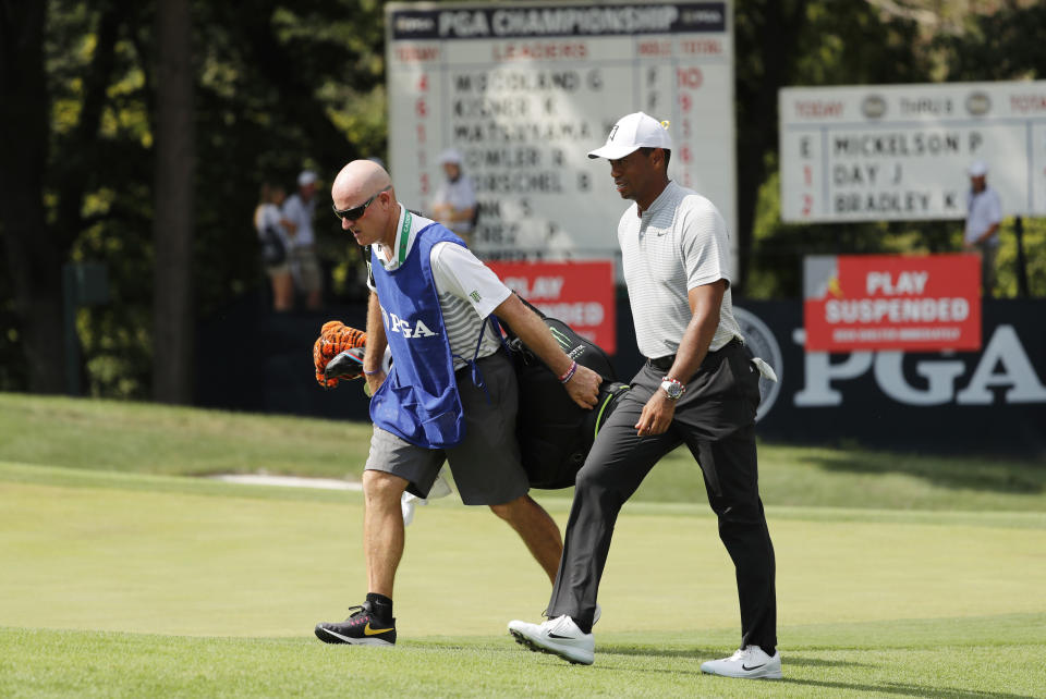 Tiger Woods, right, walks with his caddie, Joe LaCave, after play was suspended due to weather during the second round of the PGA Championship golf tournament at Bellerive Country Club, Friday, Aug. 10, 2018, in St. Louis. (AP Photo/Jeff Roberson)