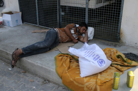 A Palestinian man rests at an aid distribution center run by United Nations Relief and Works Agency (UNRWA) in Khan Younis in the southern Gaza Strip September 1, 2018. REUTERS/Ibraheem Abu Mustafa