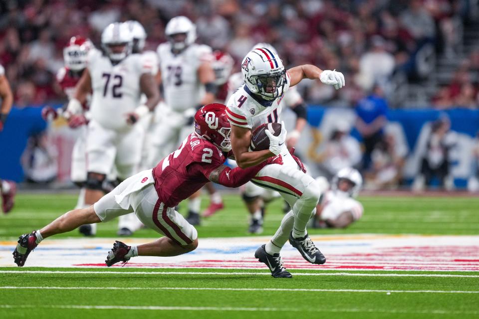 Dec 28, 2023; San Antonio, TX, USA; Oklahoma Sooners defensive back Billy Bowman Jr. (2) brings down Arizona Wildcats wide receiver Tetairoa McMillan (4) in the first half at Alamodome. Mandatory Credit: Daniel Dunn-USA TODAY Sports ORG XMIT: IMAGN-715788 ORIG FILE ID: 20231228_tdc_da8_0379.JPG