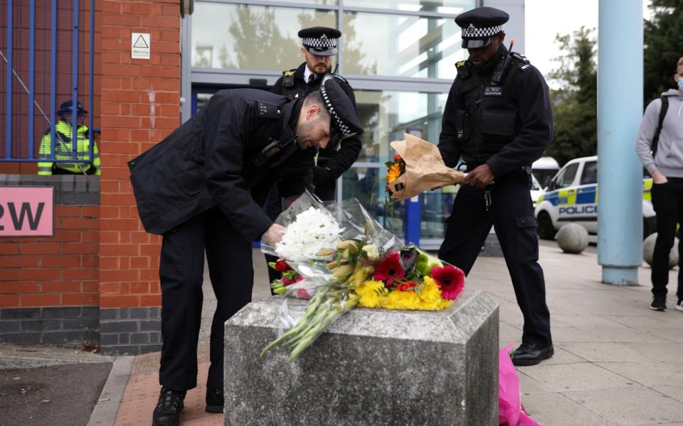 Flowers are laid down outside the custody centre where a British police officer has been shot dead in Croydon - REUTERS/Tom Nicholson