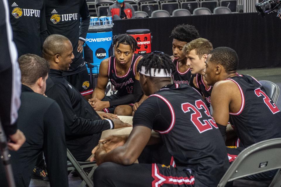 IUPUI men's basketball team in the huddle with coach Matt Crenshaw.