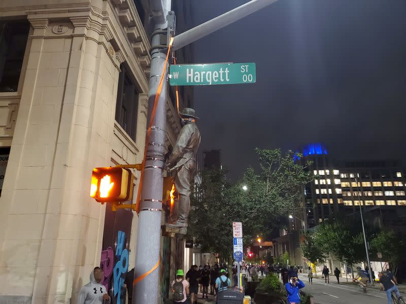 A Confederate statue is seen hanging on a street post in Raleigh