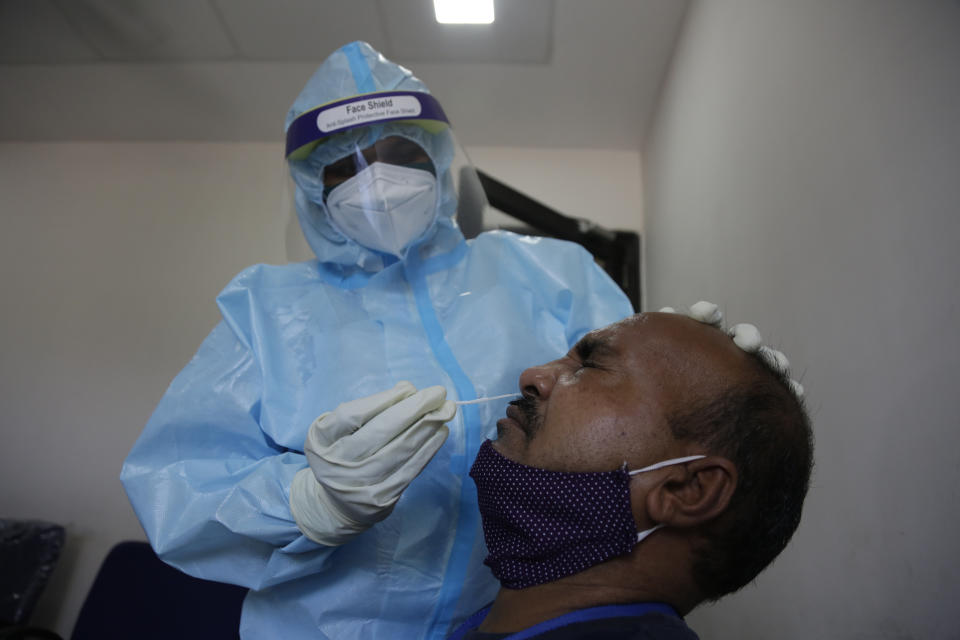 An Indian health worker takes a nasal swab sample of roadside vendor at a health center in Ahmedabad, India, Wednesday, July 8, 2020. India has overtaken Russia to become the third worst-affected nation by the coronavirus pandemic. (AP Photo/Ajit Solanki)