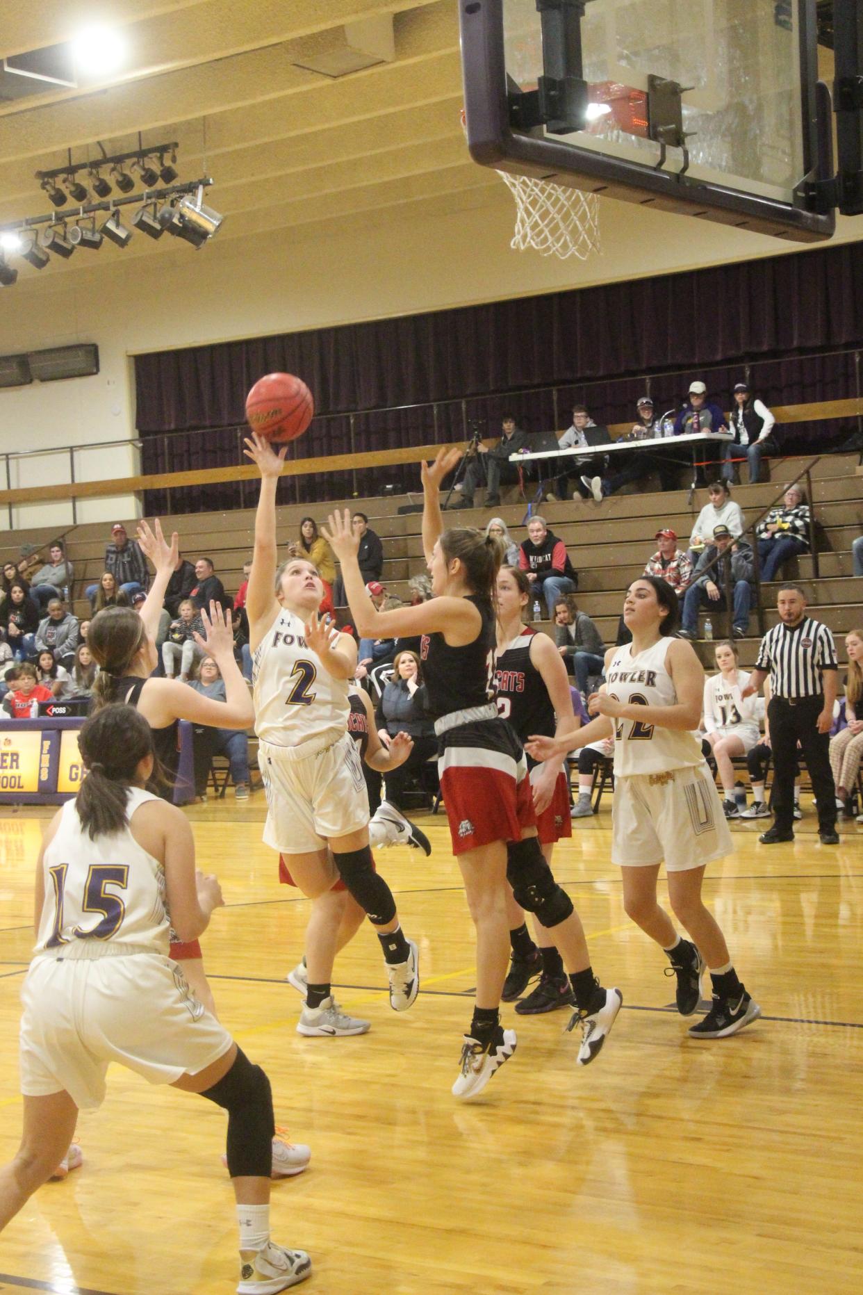 Alyssa Maestas shoots over the outstretched arm of a Holly defender as teammates Olivia Romero (15) and Gracie Osbourne (22) position themselves for an offensive rebound. Maestas led Fowler in scoring with 13 points.