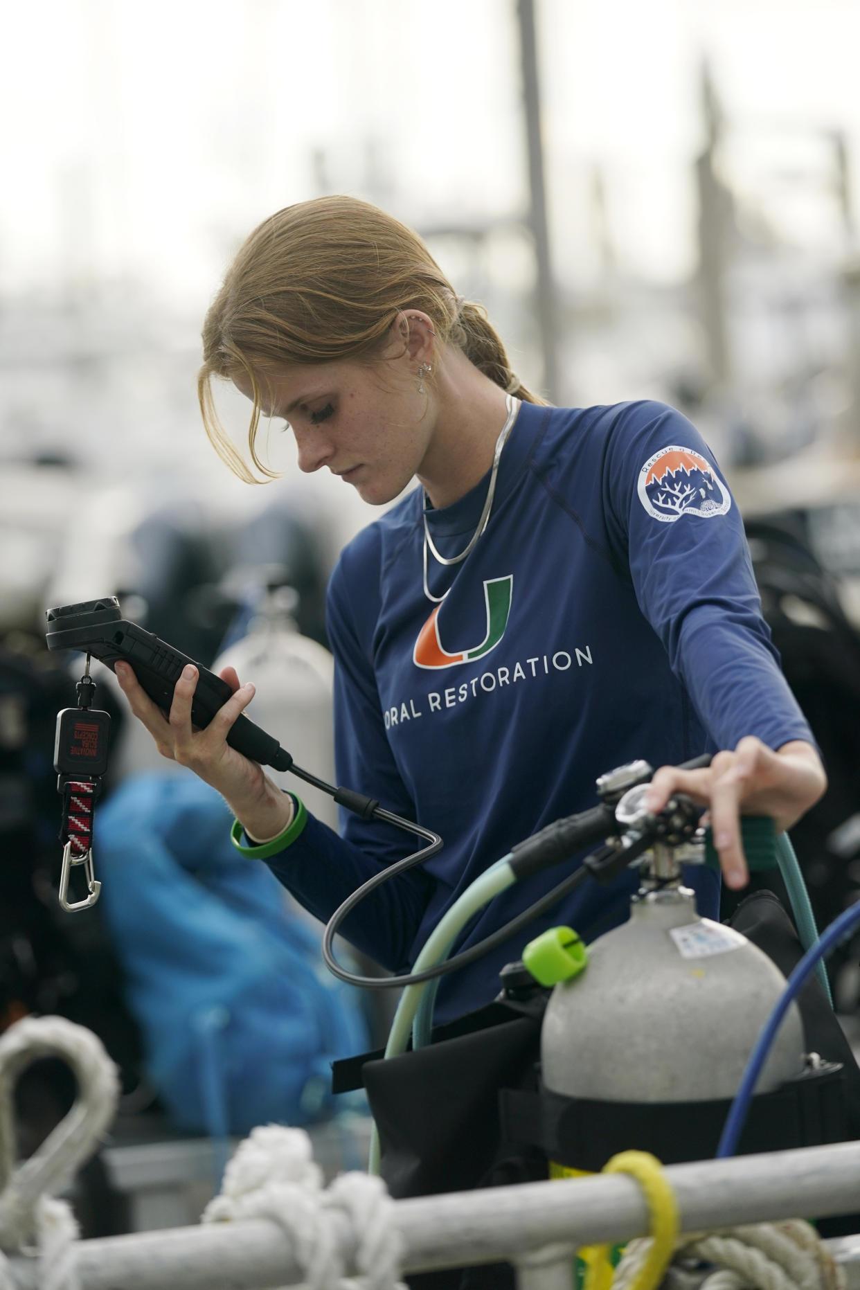 University of Miami's Rosenstiel School of Marine & Atmospheric Science student Devon Ledbetter, 21, prepares her dive gear before a night dive to check on coral spawning, Monday, Aug. 15, 2022, in Key Biscayne, Fla. A group students and scientists were hoping to observe the coral spawn and collect their eggs and sperm, called gametes, to take back to the lab to hopefully fertilize and create new coral that will later be transplanted to help repopulate part of the Florida Reef Tract. (AP Photo/Wilfredo Lee)