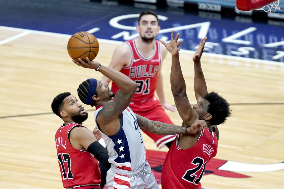 Washington Wizards' Bradley Beal, center, shoots over Chicago Bulls' Thaddeus Young and Garrett Temple (17) during the second half of an NBA basketball game Monday, Feb. 8, 2021, in Chicago. (AP Photo/Charles Rex Arbogast)