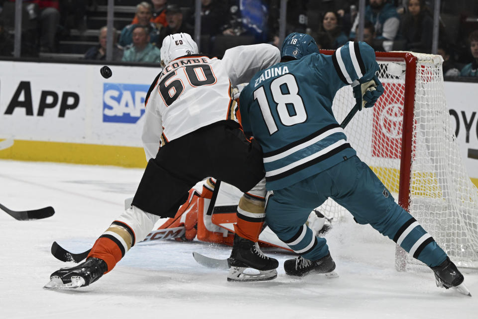 Anaheim Ducks defenseman Jackson LaCombe (60) fights for control of the puck against San Jose Sharks right wing Filip Zadina (18) during the first period of an NHL hockey game, Saturday, Jan. 20, 2024, in San Jose, Calif. (AP Photo/Nic Coury)