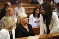 Olympic and Paralympic track star Oscar Pistorius's sister Aimee (R) speaks to Reeva Steenkamp's mother June (L), as her long time friend Jenny Strydom looks on, ahead of Oscar's trial for the murder of his girlfriend Reeva, at the North Gauteng High Court in Pretoria, March 17, 2014. Pistorius is on trial for murdering his girlfriend Reeva Steenkamp at his suburban Pretoria home on Valentine's Day last year. He says he mistook her for an intruder. REUTERS/Siphiwe Sibeko (SOUTH AFRICA - Tags: CRIME LAW SPORT ATHLETICS)