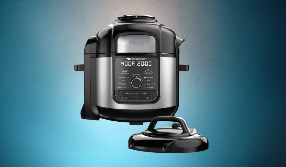 A grey and black air fryer with lid and LCD screen on the front reading the time cooking and temperature