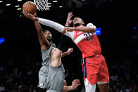 Washington Wizards' Daniel Gafford (21) drives past Brooklyn Nets' Bruce Brown (1) and Blake Griffin (2) during the first half of an NBA basketball game Monday, Oct. 25, 2021, in New York. (AP Photo/Frank Franklin II)