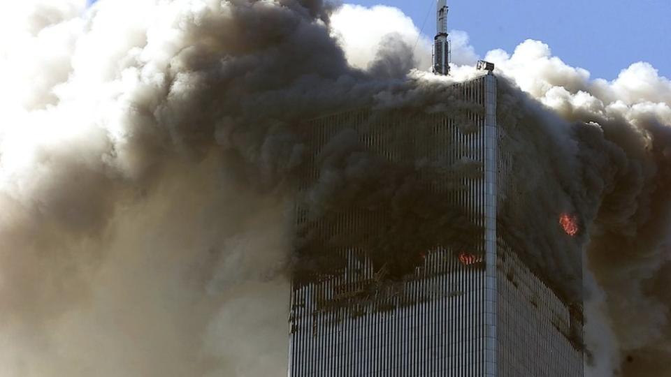 The north tower of the World Trade Center burns after being hit by a hijacked plane on 11 September 2001