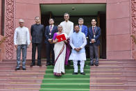 Indian Finance Minister Nirmala Sitharaman, carrying a red pouch containing budget documents, poses for a photograph with colleagues as she arrives to present the federal budget in the Parliament in New Delhi, India, Tuesday, July 23, 2024. (AP Photo)