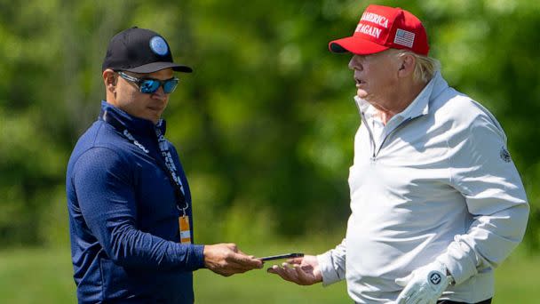 PHOTO: FILE - Walt Nauta takes a phone from former President Donald Trump during the LIV Golf Pro-Am at Trump National Golf Club, May 25, 2023, in Sterling, Va. (Alex Brandon/AP, FILE)
