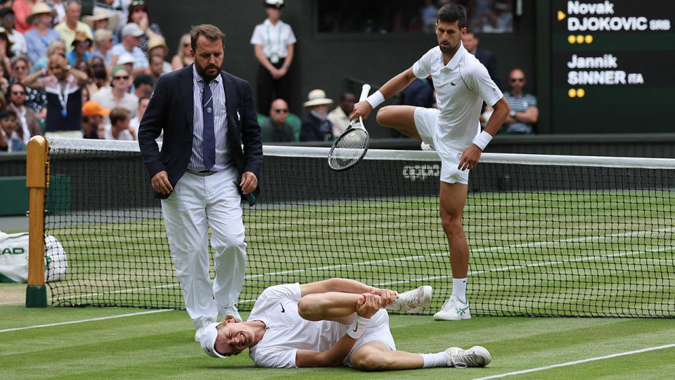 Novak Djokovic is seen jumping over the Wimbledon net to check on Jannik Sinner, who was collapsed on the ground.