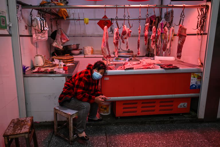 Un vendedor de carne con una máscara facial espera a un cliente en un mercado en Wuhan, el 2 de abril de 2020.