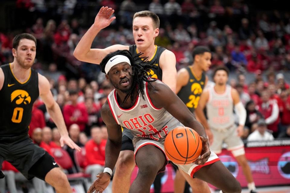 Jan 21, 2023; Columbus, OH, USA;  Ohio State Buckeyes guard Isaac Likekele (13) is defended by Iowa Hawkeyes forward Payton Sandfort (20) during the second half of the NCAA division I men’s basketball game between the Ohio State Buckeyes and the Iowa Hawkeyes at Value City Arena. Mandatory Credit: Joseph Scheller-The Columbus Dispatch