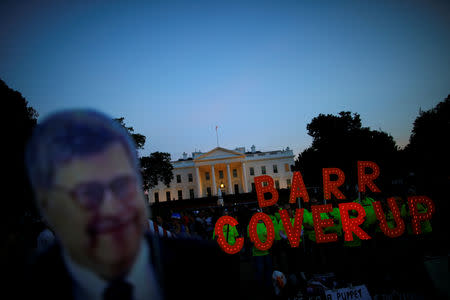 A cardboard cutout of U.S. Attorney General William Barr is seen as protesters hold signs which read "Barr Coverup," following the release of the Mueller report on U.S. President Donald Trump at the White House in Washington, U.S., April 18, 2019. REUTERS/Carlos Barria