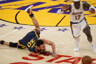 Golden State Warriors guard Stephen Curry, left, falls and looses the ball while under pressure from Los Angeles Lakers guard Dennis Schroder during the first half of an NBA basketball game Sunday, Feb. 28, 2021, in Los Angeles. (AP Photo/Mark J. Terrill)