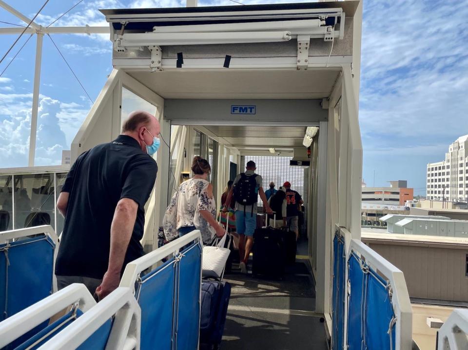 Passengers exit the ship on the final day of the cruise.