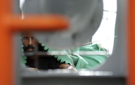 A migrant waits to disembark from the Norwegian vessel Siem Pilot Stavanger in the Sicilian harbor of Palermo, Italy June 24, 2015. REUTERS/Guglielmo Mangiapane