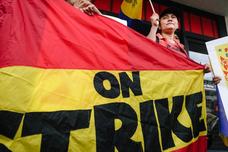 Julieta Garcia behind a banner reading "on strike"