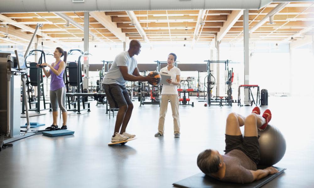 Physical therapist guiding patient with medicine ball gym