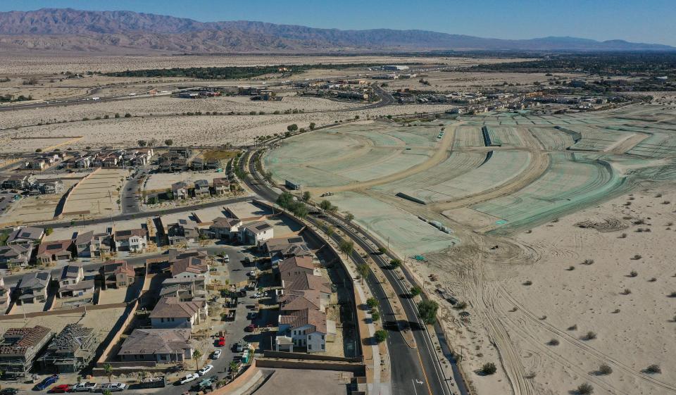 New homes in the Woodbridge Pacific development at University Park, left, and graded land for a community park, right, are under construction in Palm Desert, Dec. 8, 2022. 