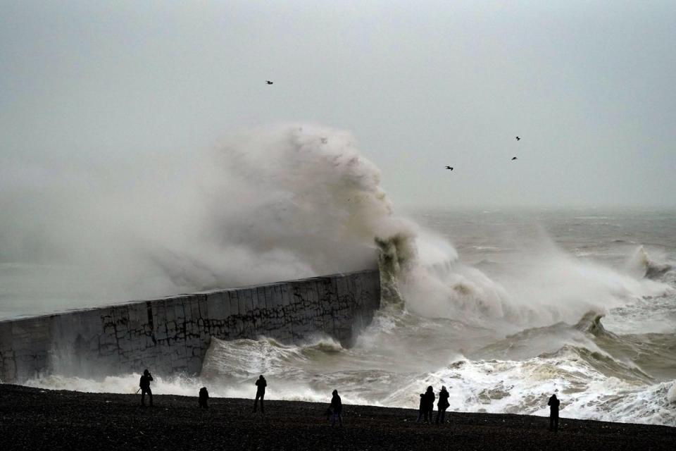 A wave crashes over Newhaven lighthouse at West Quay in East Sussex (Steve Parsons/PA) (PA Archive)