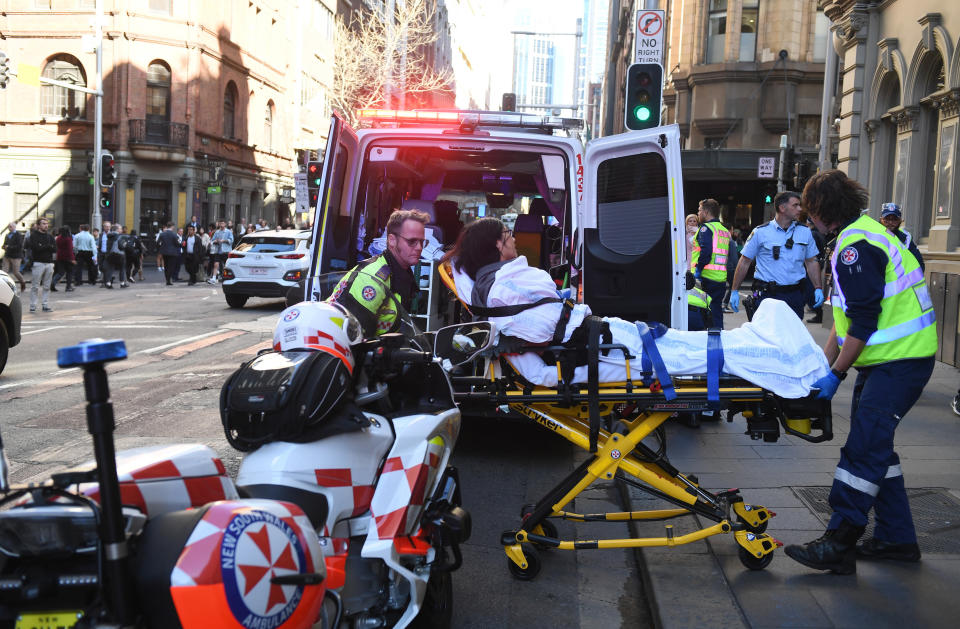 A women is taken by ambulance from Hotel CBD at the corner of King and York Street in Sydney, Australia Tuesday, Aug. 13, 2019. Police and witnesses say a young man yelling about religion and armed with a knife has attempted to stab several people in downtown Sydney before being arrested, with one woman taken to a hospital. (Dean Lewins/AAP Image via AP)