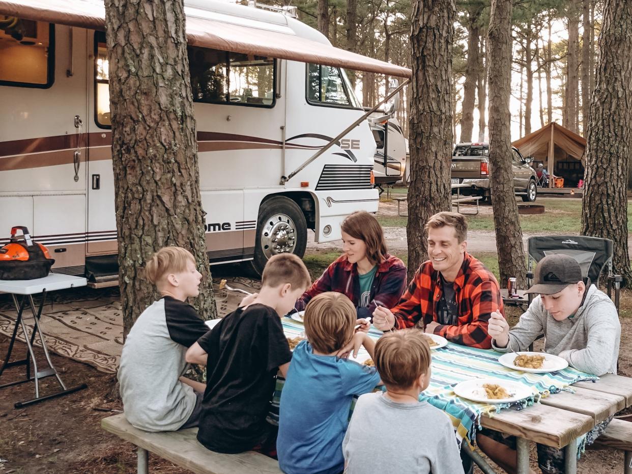 the walker family eating at a table outside in front of their RV