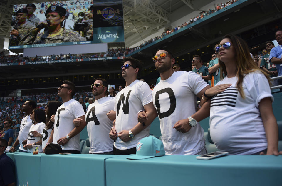 Fans at the Dolphins-Titans game in Miami have an idea what players should do during the playing of the national anthem. (AP) 