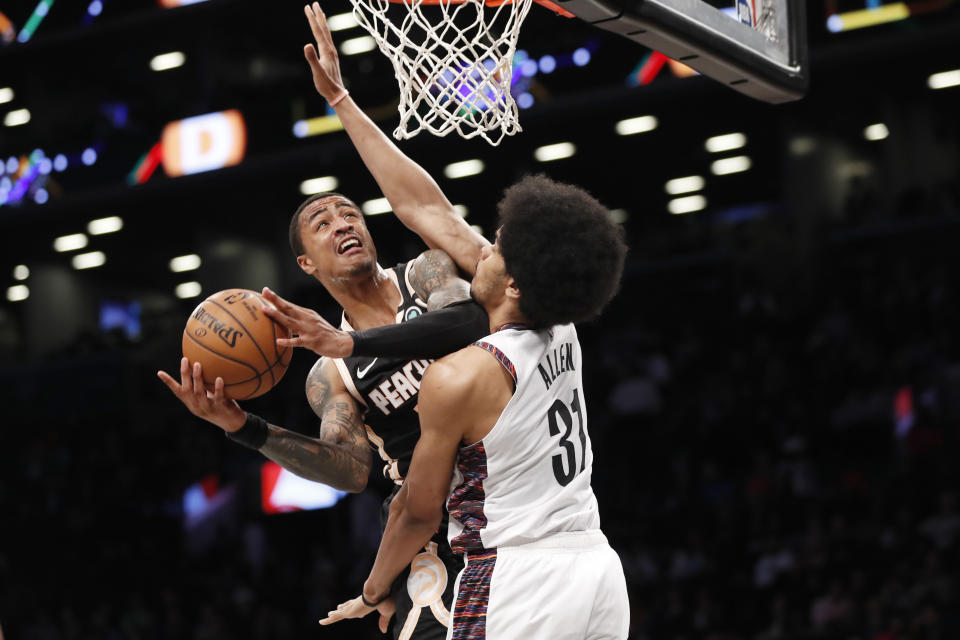 Atlanta Hawks forward John Collins (20) tries to get a shot by the defense of Brooklyn Nets center Jarrett Allen (31) during the first half of an NBA basketball game, Sunday, Jan. 12, 2020, in New York. (AP Photo/Kathy Willens)