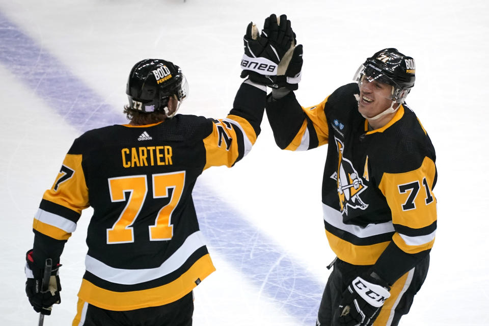 Pittsburgh Penguins' Evgeni Malkin (71) celebrates his shootout goal against the Calgary Flames with Jeff Carter in an NHL hockey game in Pittsburgh, Wednesday, Nov. 23, 2022. The Penguins won 2-1. (AP Photo/Gene J. Puskar)