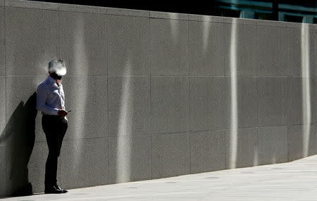 A man uses an electronic cigarette on a sunny spring day in London, in this April 14, 2015 file photo. REUTERS/Cathal MacNaughton/Files