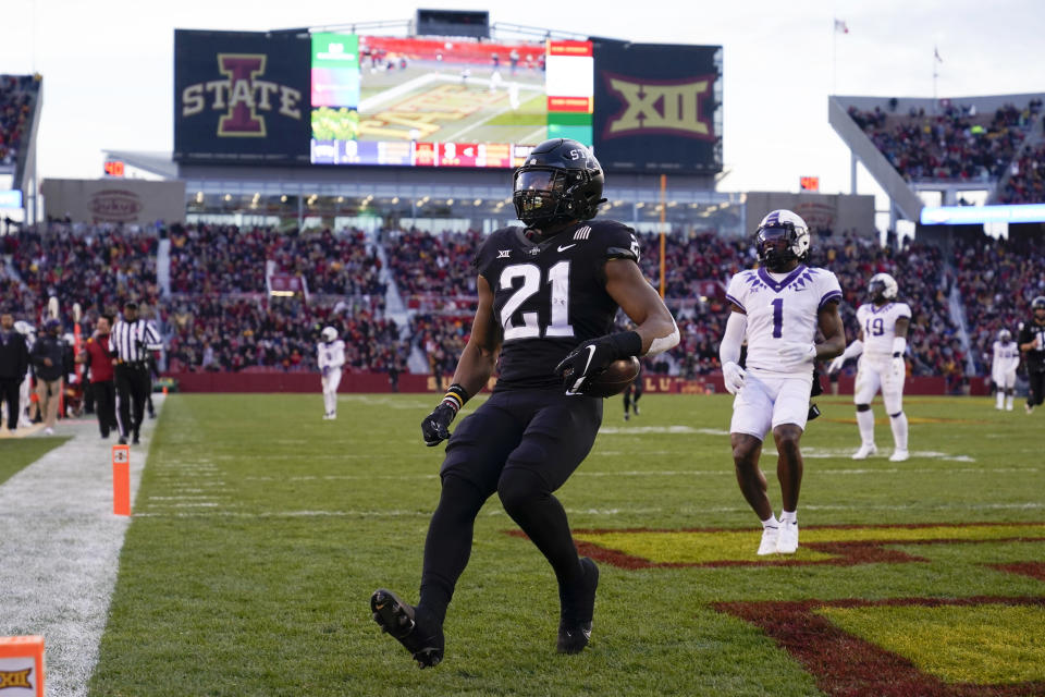 Iowa State running back Jirehl Brock (21) celebrates as he scores on a 40-yard touchdown run ahead of TCU cornerback Tre'Vius Hodges-Tomlinson (1) during the first half an NCAA college football game, Friday, Nov. 26, 2021, in Ames, Iowa. (AP Photo/Charlie Neibergall)