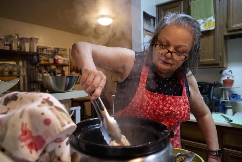 Mary Ann Estrella stirs homemade dog food inside her kitchen in Midland, Texas, on April 20, 2024. Estrella makes her own dog food to save money as living costs increase.