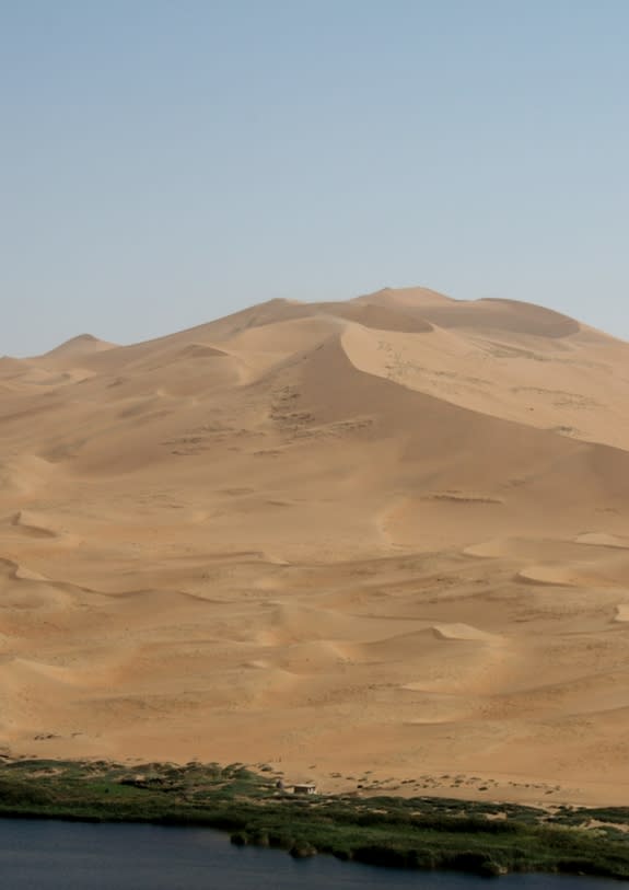 Giant dune near a lake in the Badain Jaran Desert in Inner Mongolia, China.