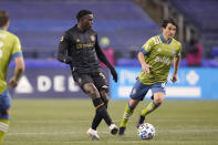 Los Angeles FC defender Jesus David Murillo, left, passes in front of Seattle Sounders midfielder Nicolas Lodeiro during the second half of an MLS playoff soccer match, Tuesday, Nov. 24, 2020, in Seattle. (AP Photo/Ted S. Warren)