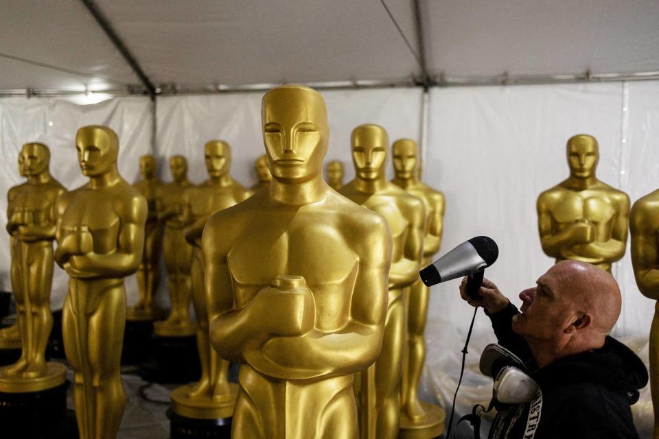 A worker puts the final touches on an Oscar statue before it is placed on display at the 95th Academy Awards in Los Angeles, California, on March 10, 2023. 