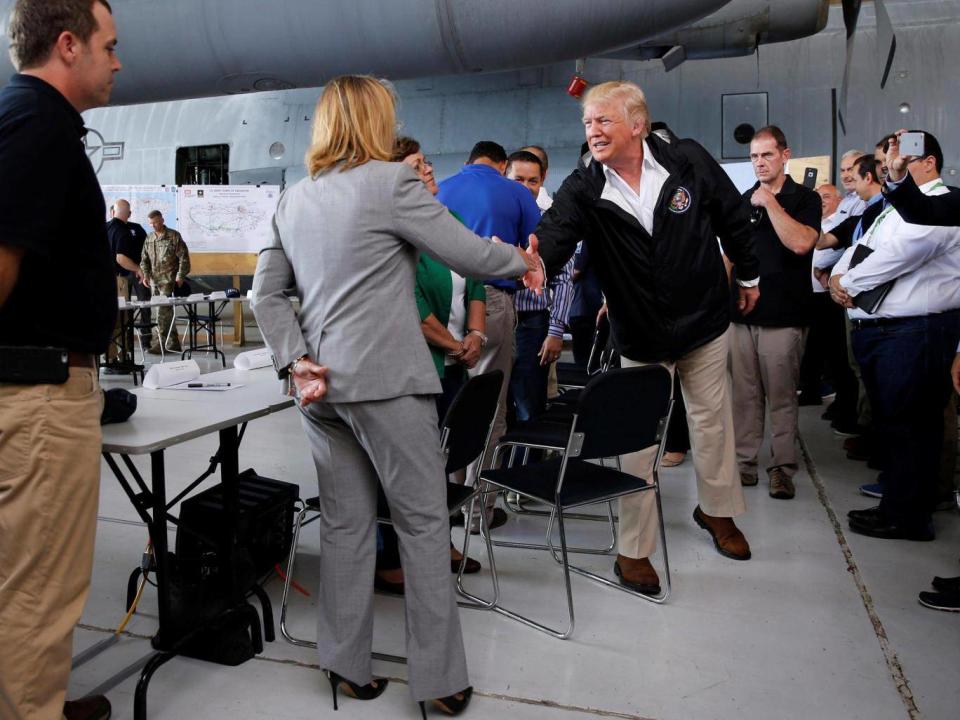 Carmen Yulin Cruz shakes hands with a humbled US President Donald Trump after he criticised her leadership in the the aftermath of Hurricane Maria (Jonathan Ernst/Reuters)