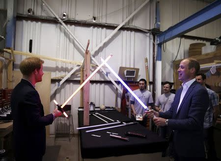 Britain's Prince William (R) tries a light sabre against his brother Prince Harry during a visit to the Star Wars film set at Pinewood Studios near Iver Heath, west of London, Britain, April 19, 2016. REUTERS/Adrian Dennis/Pool