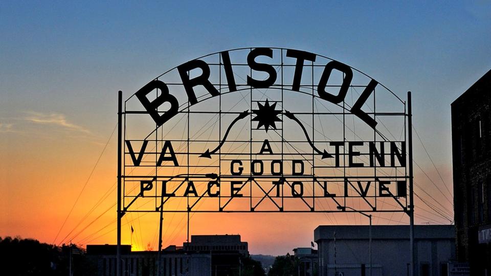 a large sign with a sunset in the background