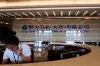 FILE PHOTO: An employee speaks on the phone at the reception of Hengli Petrochemical's new refining, petrochemical complex, at Changxing island in Dalian