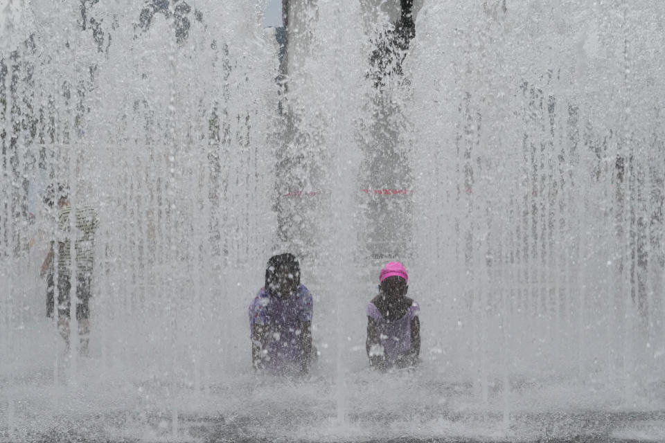 Children cool themselves off in a public fountain in Seoul, South Korea, Thursday, July 25, 2024. A heat wave warning was issued in Seoul as temperatures soared 33 degrees Celsius (91.4 degrees Fahrenheit). (AP Photo/Ahn Young-joon)