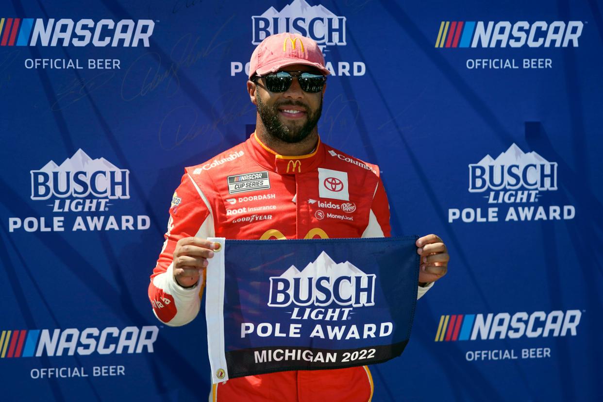 Bubba Wallace celebrates after winning the pole position during NASCAR Cup Series auto race qualifying at the Michigan International Speedway in Brooklyn, Mich., Saturday, Aug. 6, 2022. (AP Photo/Paul Sancya)